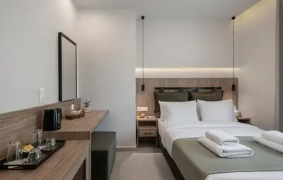 a bedroom with a bed and a desk with a mirror at Morum City Hotel Chania in Chania Town