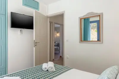a bedroom with a bed with a tv and two slippers at Pano Stalos Villas in Stalos