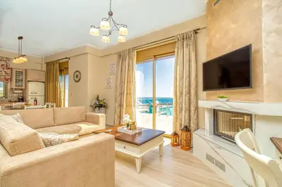 a living room with a couch and a tv and a fireplace at Luxuryvillaschania Kore-Falasarna beach in Falasarna