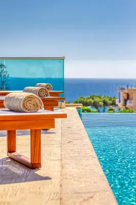 a wooden bench next to a swimming pool at Luxuryvillaschania Kore-Falasarna beach in Falasarna
