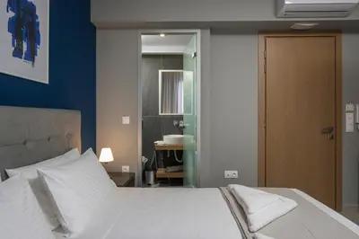 a bedroom with a white bed with a blue wall at MIRMA CITY Old Town in Chania Town