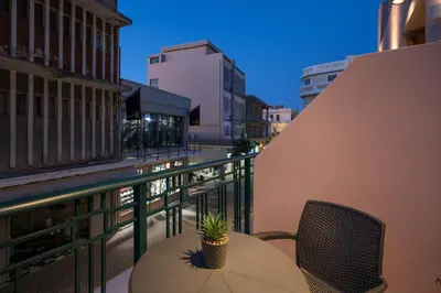 a table with a potted plant sitting on a balcony at MIRMA CITY Old Town in Chania Town