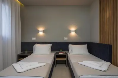 a room with two beds and a table and lights at MIRMA CITY Old Town in Chania Town
