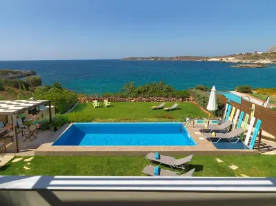 a swimming pool with chairs and a view of the ocean at Villa Anemos by Estia in Kalathas