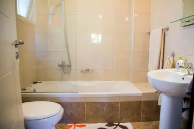 a bathroom with a tub and a toilet and a sink at Villa Nopigia Homeleader in Nopíyia