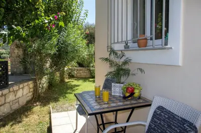 a table and chairs on a patio with a window at Villa Nopigia Homeleader in Nopíyia