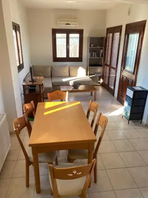 a living room with a table and chairs and a couch at Villa Darmarohori Homeleader in Darmarochori