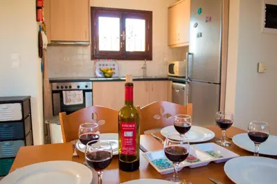 a bottle of wine sitting on a table with wine glasses at Villa Darmarohori Homeleader in Darmarochori