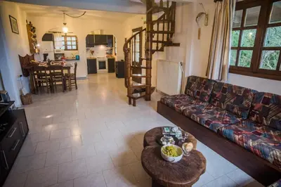 a living room with a couch and a table at Villa Papoura Homeleader in Delimanolianá