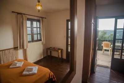 a bedroom with a bed and a door to a balcony at Villa Papoura Homeleader in Delimanolianá