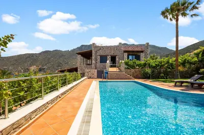 a villa with a swimming pool in front of a house at Kambos Horizon & Paradise Villas in Kissamos
