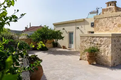 a courtyard of a house with potted plants at Eliana's Stone House in Benoudhianá