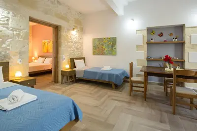a hotel room with two beds and a desk at Eliana's Stone House in Benoudhianá