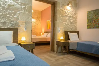 a hotel room with two beds and a mirror at Eliana's Stone House in Benoudhianá