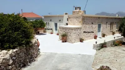a house with a stone wall and a driveway at Eliana's Stone House in Benoudhianá
