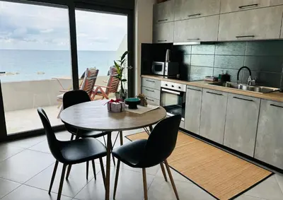 a kitchen with a table and chairs and the ocean at zonapartments A sea view-city center in Chania Town