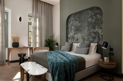 a bedroom with a bed with a large headboard at Malmo Historic Hotel in Chania Town