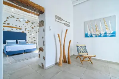 a bedroom with a bed and a chair in it at Veranta Luxury Suite in Khóra Sfakíon