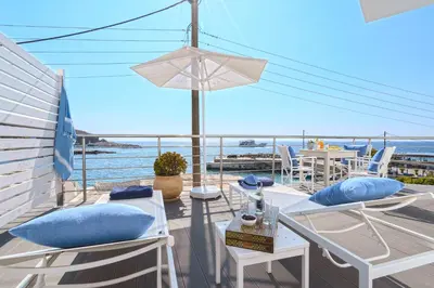 a balcony with chairs and a table and a view of the ocean at Veranta Luxury Suite in Khóra Sfakíon