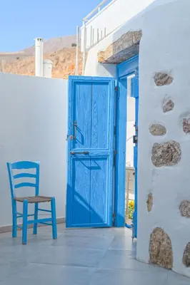 a blue door and a chair in front of a building at FantaSea Luxury Suite in Khóra Sfakíon