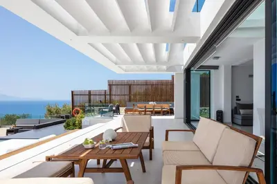 an outdoor patio with furniture and a view of the ocean at Regal Residence in Chania Town
