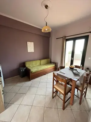 a living room with a table and a couch at Girogiali Apts in Kissamos
