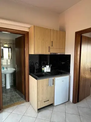 a kitchen with wooden cabinets and a white refrigerator at Girogiali Apts in Kissamos