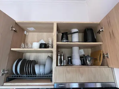 a cupboard filled with plates and utensils at Girogiali Apts in Kissamos