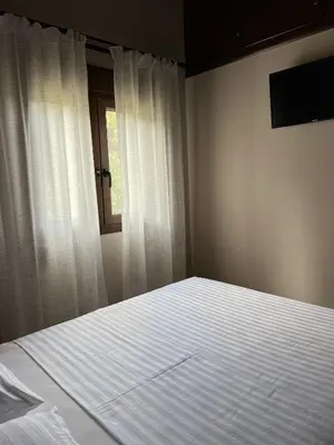 a bedroom with a white bed with a window at Serenity Resort in Vrísai