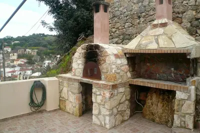 an outdoor oven with a stone wall at Serenity Resort in Vrísai