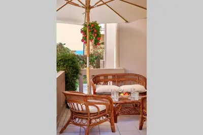 a table and chairs with an umbrella on a patio at Natasha's Luxury apartment by the sea in Galatás
