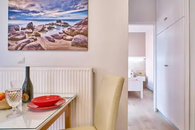 a dining room with a table and a painting on the wall at Natasha's Luxury apartment by the sea in Galatás