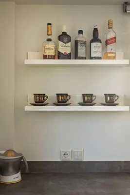 a shelf with bottles of alcohol and bowls on it at Villa Nina with Private Pool in Kolymvari