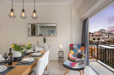 a dining room with a table and a balcony at CALMERA Luxury Living in Chania Town