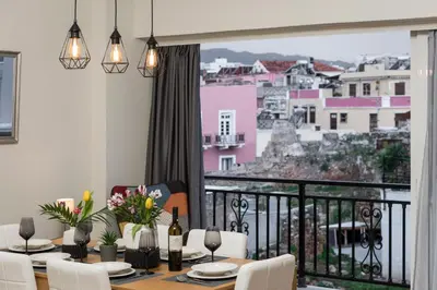 a dining room with a table and a balcony at CALMERA Luxury Living in Chania Town