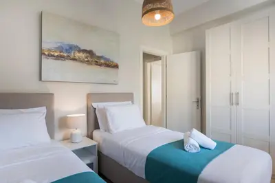 a bedroom with two beds and a painting on the wall at CALMERA Luxury Living in Chania Town