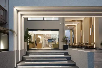 a lobby of a building with stairs and tables at Sapphire Blue Suites in Kissamos