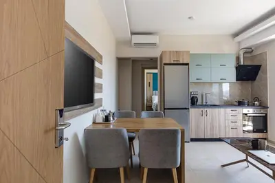 a kitchen and dining room with a wooden table and chairs at Sapphire Blue Suites in Kissamos