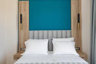 a bed with two white pillows and a blue wall at Sapphire Blue Suites in Kissamos