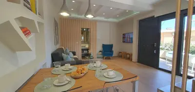 a kitchen and living room with a table and chairs at Blueonar in Chania Town