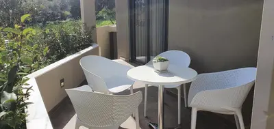 a small white table and chairs on a balcony at Blueonar in Chania Town