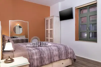 a bedroom with a bed and a tv on a wall at Estia Luxury Living in Chania Town