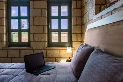 a laptop computer sitting on a bed with windows at Estia Luxury Living in Chania Town