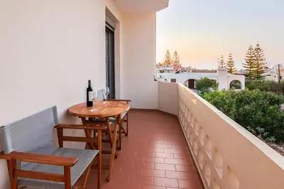 a balcony with a table and chairs and a window at Villa Krini in Kalathas