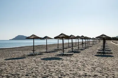 a row of umbrellas on a sandy beach at Caldera Creta Paradise in Plataniás