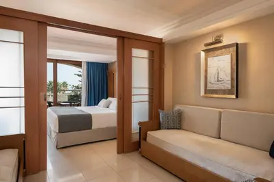 a hotel room with a bed and a couch at Caldera Creta Paradise in Plataniás