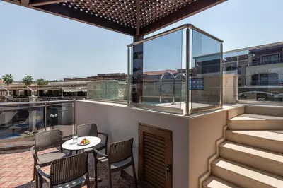 a balcony with a table and chairs on a building at Caldera Creta Paradise in Plataniás