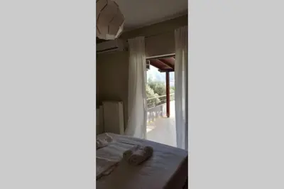 a room with a bed and a door to a porch at Blue and green in Chania Town