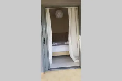 a sliding glass door leading to a bedroom with a bed at Blue and green in Chania Town