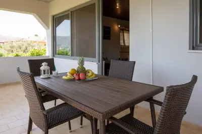 a dining room table with chairs and fruit on it at Blue and green in Chania Town